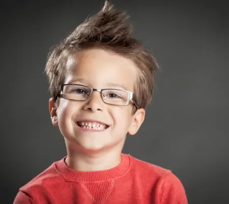 Smiling young boy in glasses and a red sweater